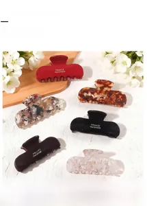 Detailed macro view of six handmade French style acetate hair claw clips in various colors