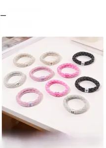 Nahaufnahme bunter karierter elastischer Haargummis mit dekorativen Good Karma Metall-Labels