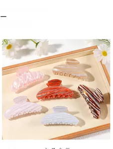 Detail view of large hair claw clips with colorful gradient patterns and wavy textures