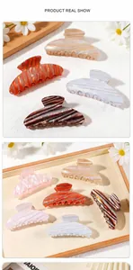 Detail view of large iridescent striped hair claws in assorted pastel pearlescent colors