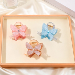 Trois élégantes pinces à cheveux papillon en cristal, coloris rose, bleu et champagne