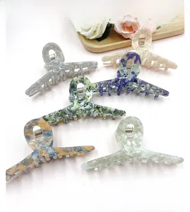 Close-up of marble pattern acetate hair claws with sturdy metal spring and cross teeth