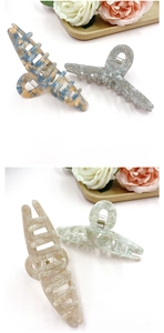 Detail showing four marble patterned large hair claw clips with strong metal springs