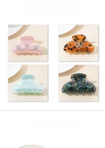 Detail of acetate shark hair claws with rhinestones in pink, leopard, and marble green