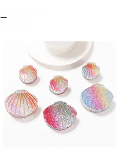 Close-up of shell-shaped colorful hair claw clips with glitter finish on white background