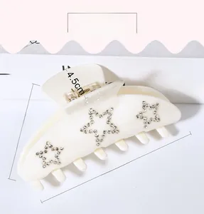 Detailed view of 9.8cm cream hair claw clip with three sparkling rhinestone stars