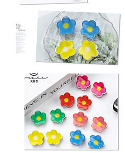 Detailed view of colorful 2cm flower hair claws in resin material on a glass display tray