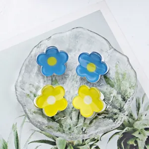 2cm floral hair clips in blue and yellow resin displayed on a glass tray for women