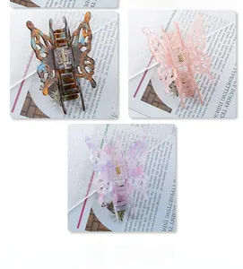 Detailed view of butterfly hair claws in amber, peach pink, and floral lavender tones
