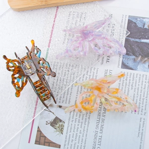 Three elegant butterfly hair claws in tortoise shell, purple and orange colors