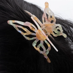 Chic butterfly hair claw clip with colorful marble pattern shown on black straight hair