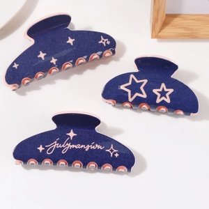 Three-piece set of navy blue hair claws with pink star patterns and carved logo detail