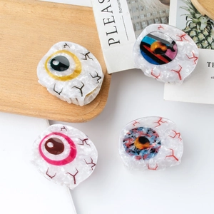 Pinces à cheveux originales motif œil avec pupilles colorées sur plateau blanc élégant