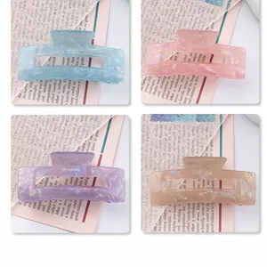 Detailed view of four colorful marble texture rectangular hair claws in pastel shades