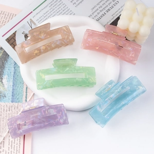Five candy-colored matte rectangle hair claws in a curated aesthetic lifestyle setting