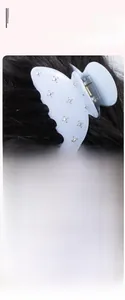 Détail de la pince à cheveux papillon bleu clair ornée de strass sur les cheveux