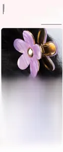 Dettaglio della molletta per capelli a fiore in marmo viola su capelli neri e oro