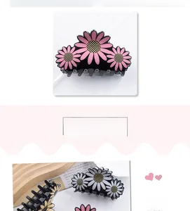 Détail d'une pince à cheveux fleur de marguerite noire 8cm aux pétales roses et blancs