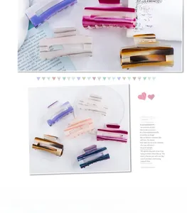 Detailed grid of striped acetate hair claws in various marble colors on a glass tray