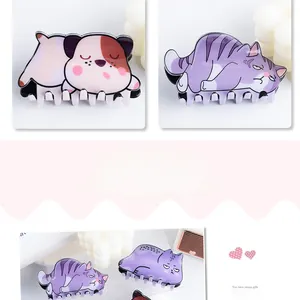 Detail view of cute cartoon animal hair claws with cat and dog designs in bright PVC