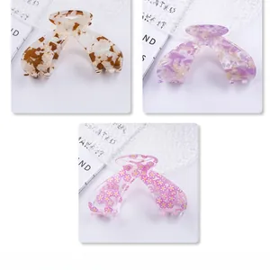 Detailed comparison of butterfly hair claws in tortoise, marble, and floral acetate patterns