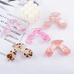 Pink floral and marble acetate butterfly hair claws set on a white decorative table