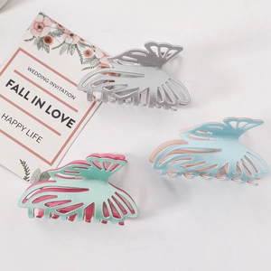 Three glitter butterfly hair claws in silver, blue, and mint green on a white background