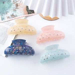 Set of 4 colorful marble hair claws with rhinestone accents on a white background
