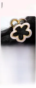 Detail view of flower-shaped hair claw with pink marble texture and gold metal frame