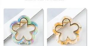 Detail view of flower-shaped hair claws made of acetate and gold metal frames