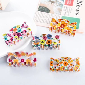 Cinq pinces à cheveux à motifs floraux et design de nœud sur un fond blanc épuré