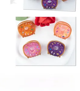 Close-up of donut-shaped candy-colored hair claws with rainbow sprinkle patterns