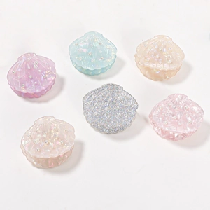 Shell shaped hair claw clips with pearls in various colors on a clean white background
