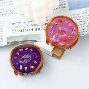 Cute doughnut hair claws set with colorful sprinkles and marble texture on newspaper background
