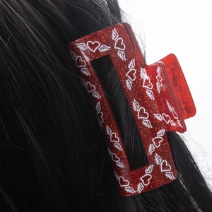 Sparkly red acrylic hair claw clip with winged heart patterns for thick hair