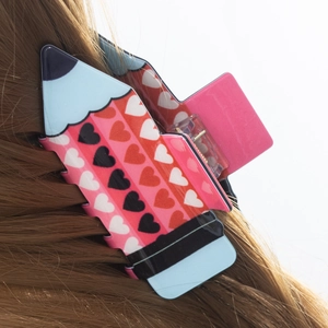 Cute pencil-shaped hair claw clip with colorful heart patterns for creative hairstyling