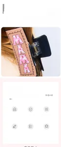 Detail view of large acrylic hair claw clip with MAMA letter design on brown long hair