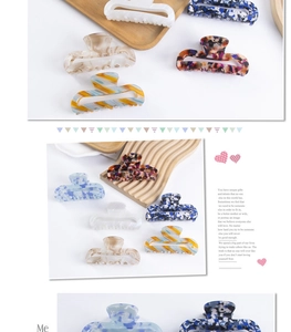 Detail of assorted marble and tortoiseshell pattern PVC hair claws on a wooden tray
