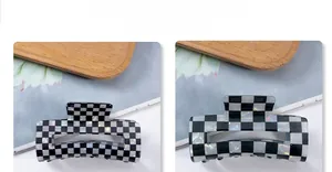 Detail of checkered hair claw clip featuring black and white pearlescent acetate texture
