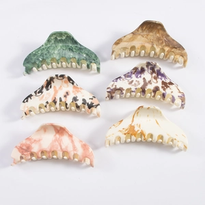 Set of 6 marble pattern acetate hair claws in various colors on white background
