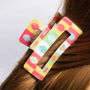 Easter egg patterned square hair claw clip in vibrant pink and green on brown hair
