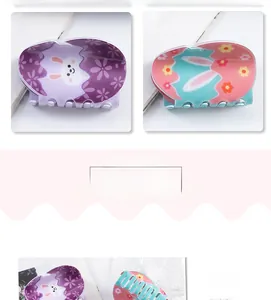 Detail view of large PVC hair claws with cute Easter bunny and carrot cartoon patterns