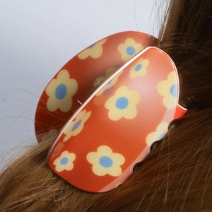 Colorful Easter flower hair claw clip for women in orange resin on brown hair