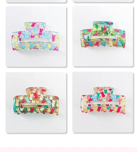 Close-up of four semi-transparent PVC hair claws with colorful cute rabbit patterns