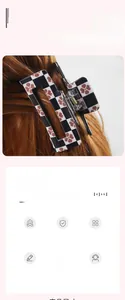 Detailed close-up of a large checkered hair claw clip with pink flowers on brown hair