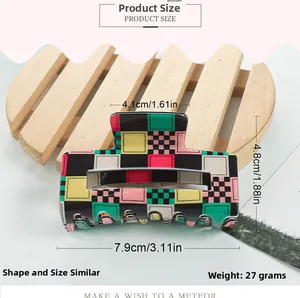 Detail of colorful checkerboard claw clip showing glossy acrylic surface and dimensions