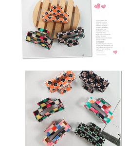 Flat lay of retro checkerboard and floral pattern acrylic claw clips in various colors