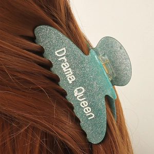 Pince à cheveux verte pailletée Drama Queen portée sur des cheveux longs brun foncé