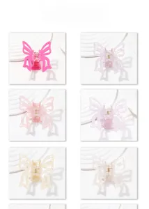 Detail showing butterfly hair claw clips in six colors on a wavy white display board