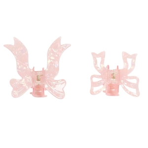 Set of two pink pearlescent ribbon-shaped PVC hair claws with stylish bow design